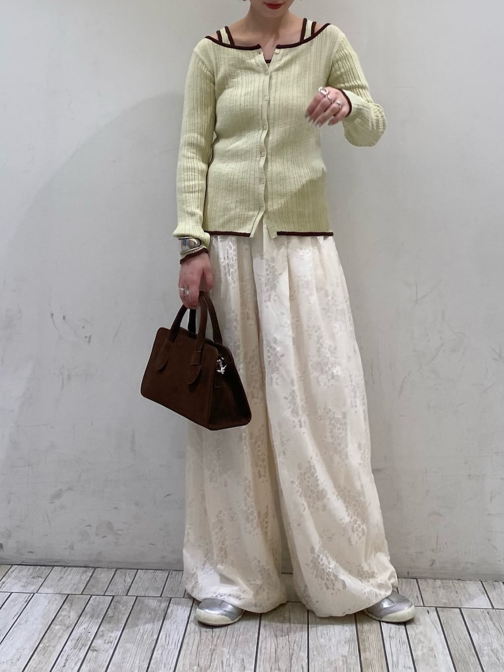 ホワイト系のその他パンツ、グリーン系のニット/セーター、ブラウン系のボストンバッグを着用したレディースの春コーディネートの2枚目の写真