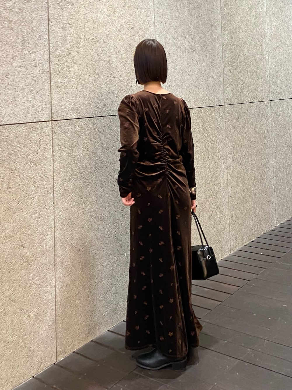 ブラウン系のワンピース、ブラック系のショルダーバッグ、ブラック系のブーツを着用したレディースの冬コーディネートの2枚目の写真