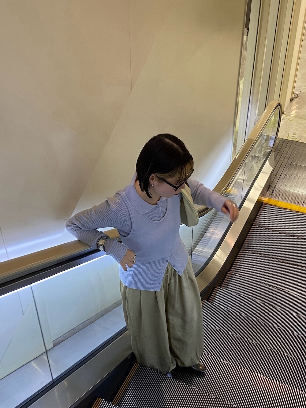 ベージュ系のその他パンツ、ホワイト系のハンドバッグ、ブルー系のニット/セーターを着用したレディースの冬コーディネートの5枚目の写真