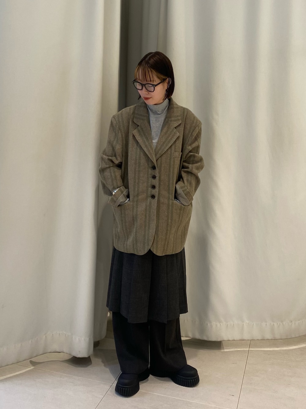 グリーン系のその他アウター、グレー系のTシャツ/カットソー、グリーン系のスカートを着用したレディースの秋コーディネートの2枚目の写真