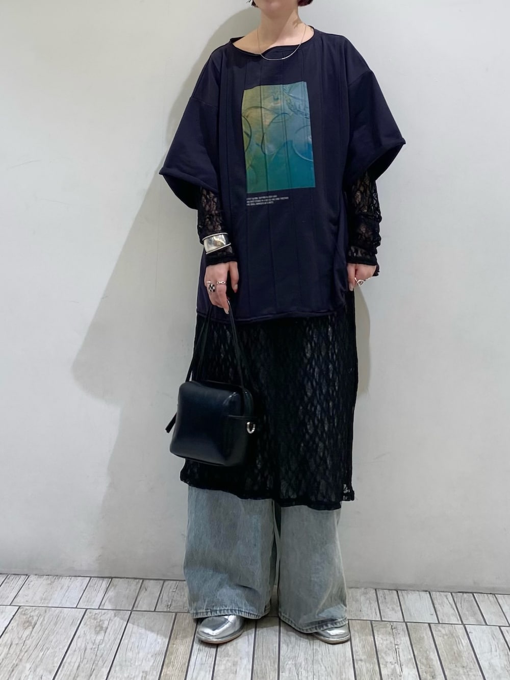 ブルー系のデニムパンツ、ブルー系のTシャツ/カットソー、ブラック系のショルダーバッグを着用したレディースの春コーディネートの2枚目の写真