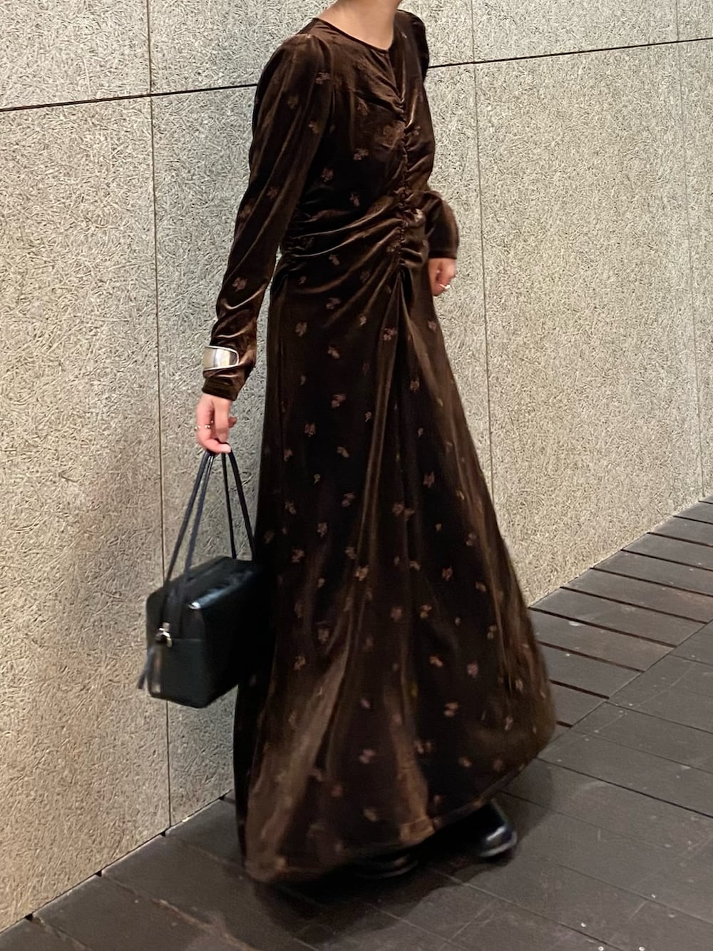 ブラウン系のワンピース、ブラック系のショルダーバッグ、ブラック系のブーツを着用したレディースの冬コーディネートの6枚目の写真