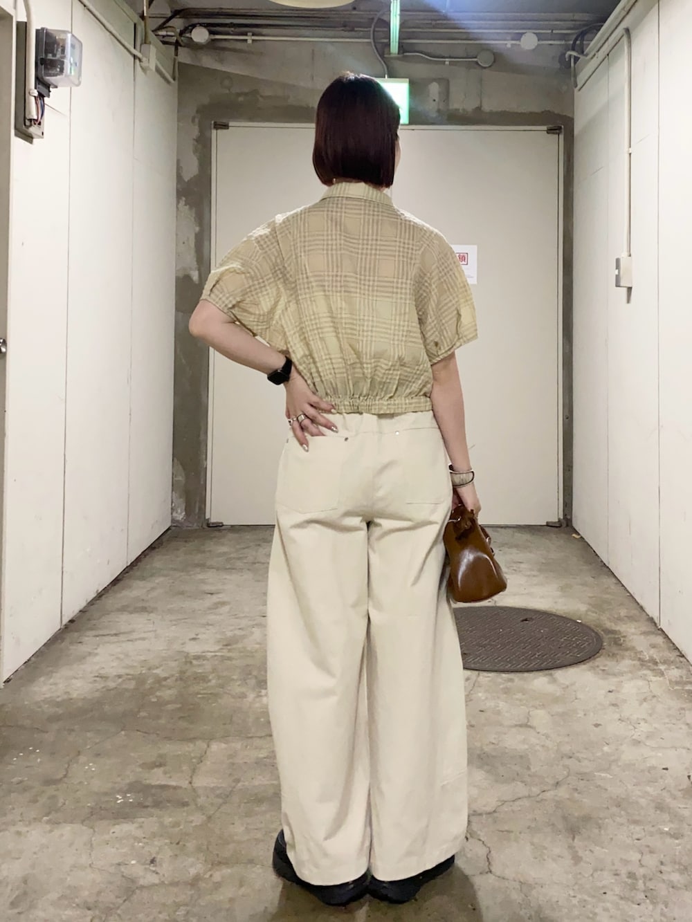 イエロー系のシャツ/ブラウス、ホワイト系のその他パンツ、ブラウン系のハンドバッグを着用したレディースの夏コーディネートの3枚目の写真