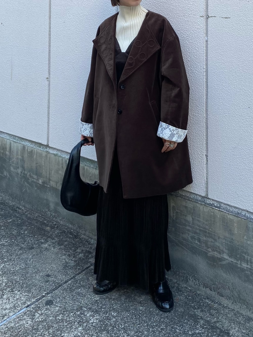 ブラック系のハンドバッグ、ブラウン系のワンピース、ブラック系のその他シューズを着用したレディースの冬コーディネートの2枚目の写真