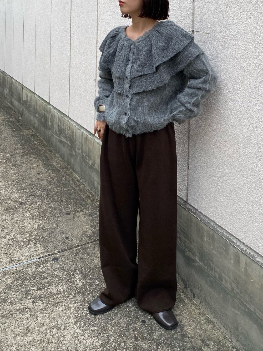 グレー系のニット/セーター、ブラウン系のその他パンツ、グレー系のその他シューズを着用したレディースの秋コーディネートの4枚目の写真