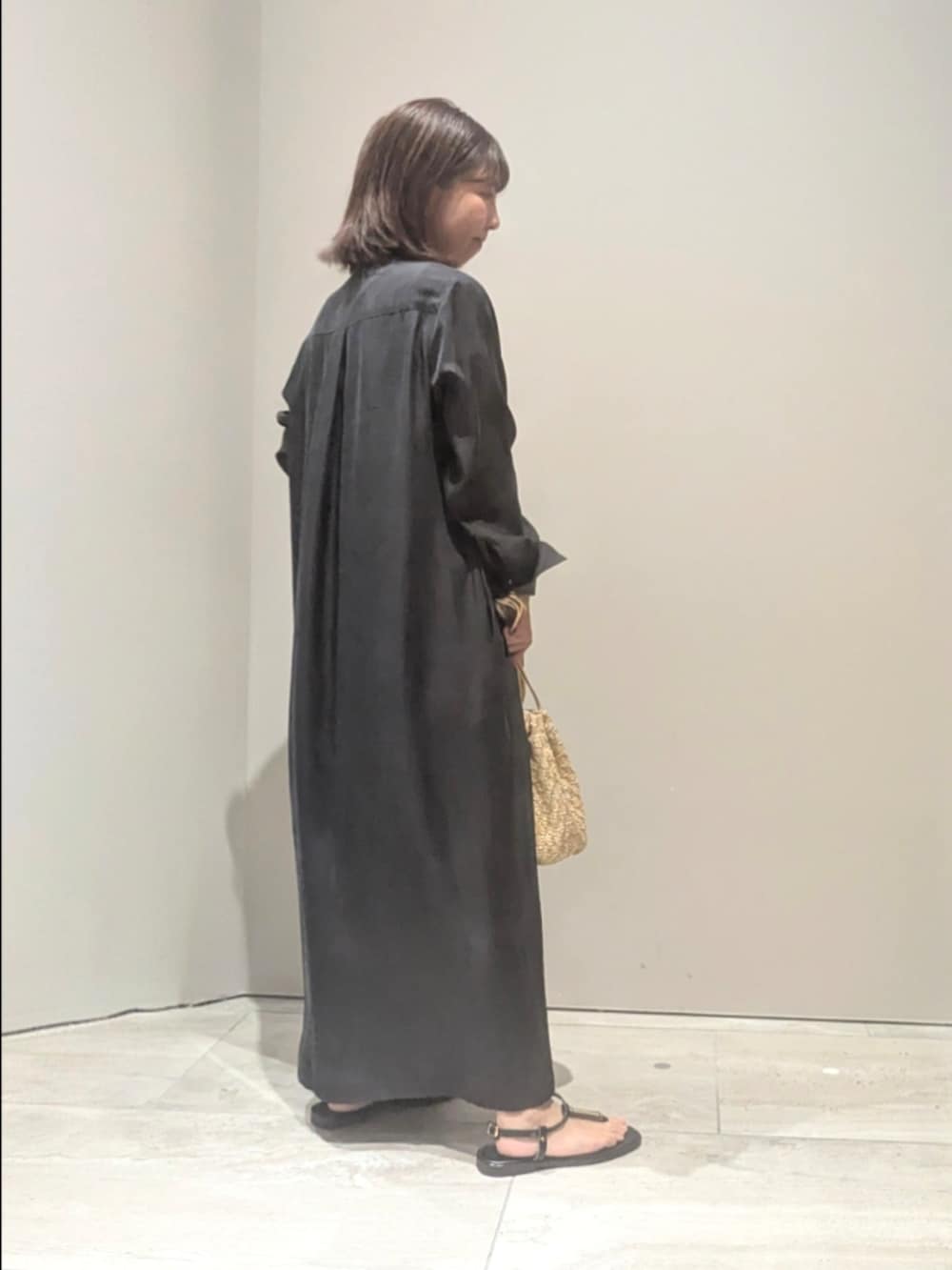 ブラック系のワンピース、ゴールド系のショルダーバッグ、シルバー系のバングル/リストバンドを着用したレディースの春コーディネートの3枚目の写真