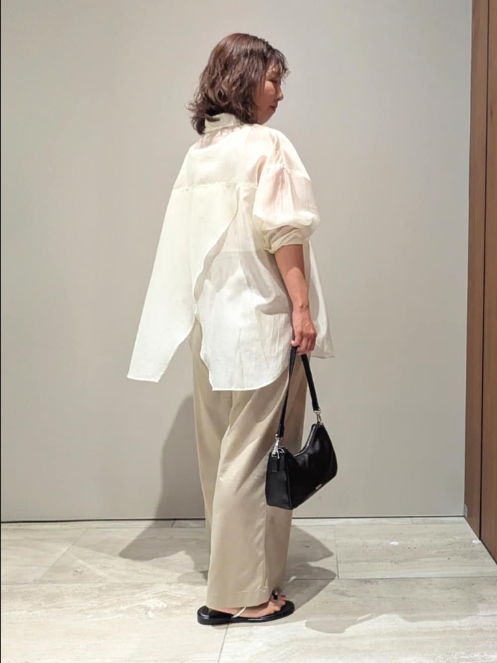 ベージュ系のその他パンツ、ホワイト系のシャツ/ブラウス、ホワイト系のタンクトップを着用したレディースの春コーディネートの3枚目の写真