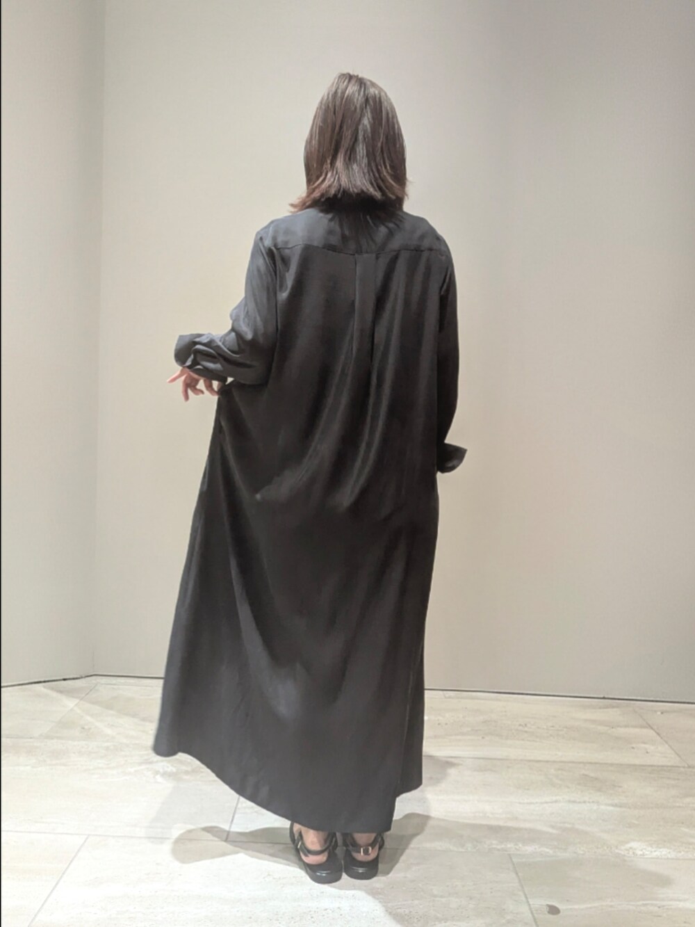 ブラック系のワンピース、ゴールド系のショルダーバッグ、シルバー系のバングル/リストバンドを着用したレディースの春コーディネートの5枚目の写真