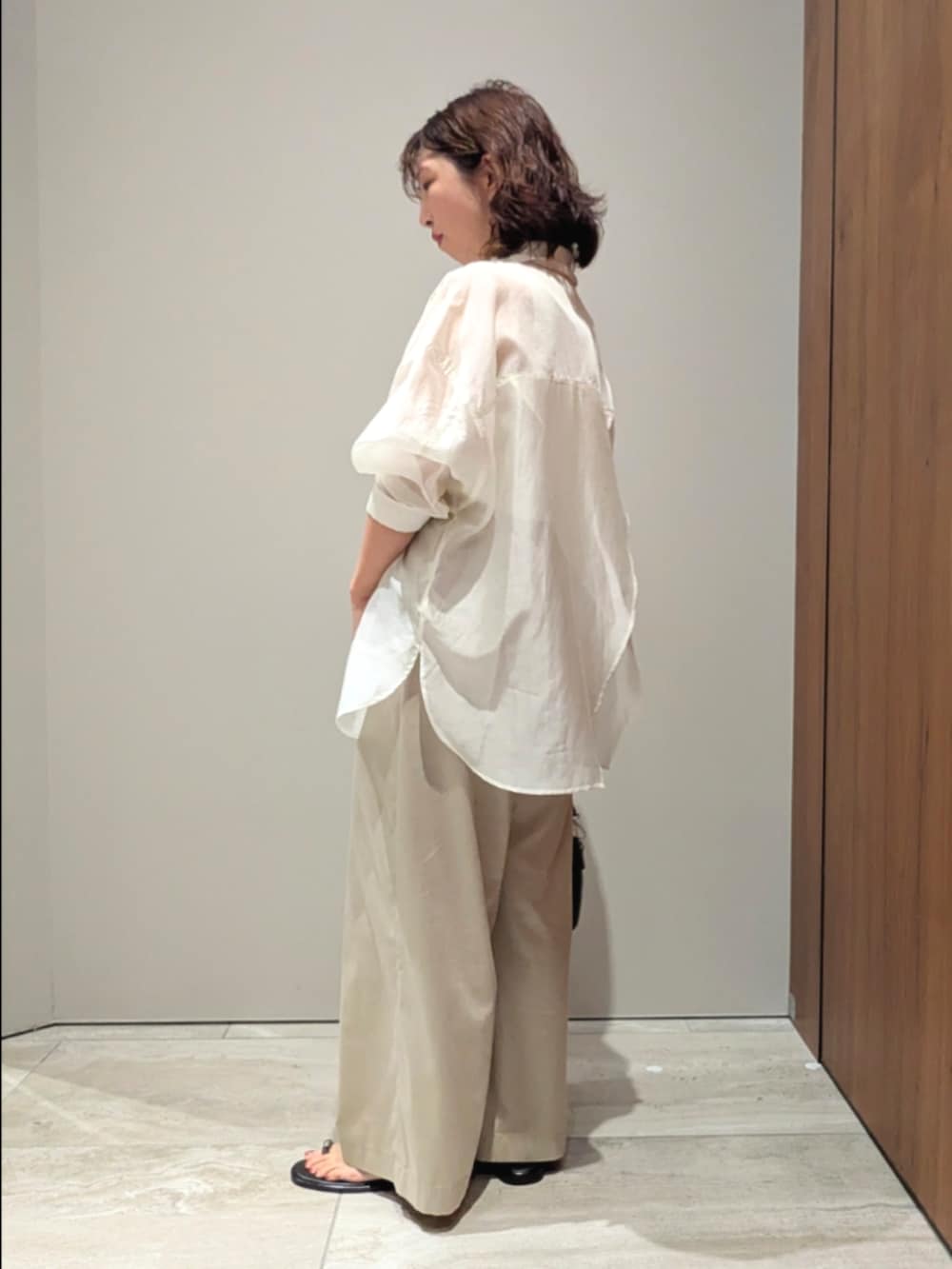 ベージュ系のその他パンツ、ホワイト系のシャツ/ブラウス、ホワイト系のタンクトップを着用したレディースの春コーディネートの2枚目の写真
