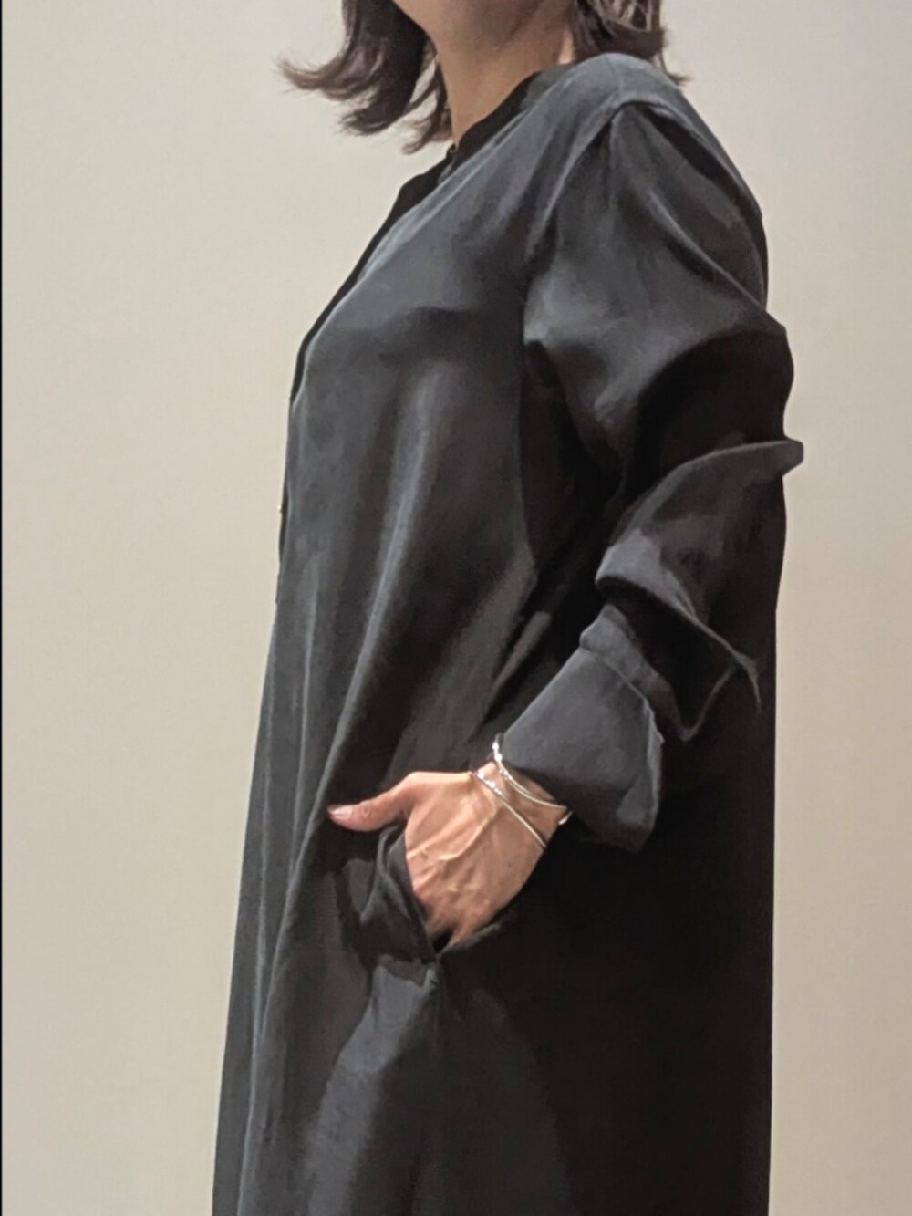 ブラック系のワンピース、ゴールド系のショルダーバッグ、シルバー系のバングル/リストバンドを着用したレディースの春コーディネートの2枚目の写真