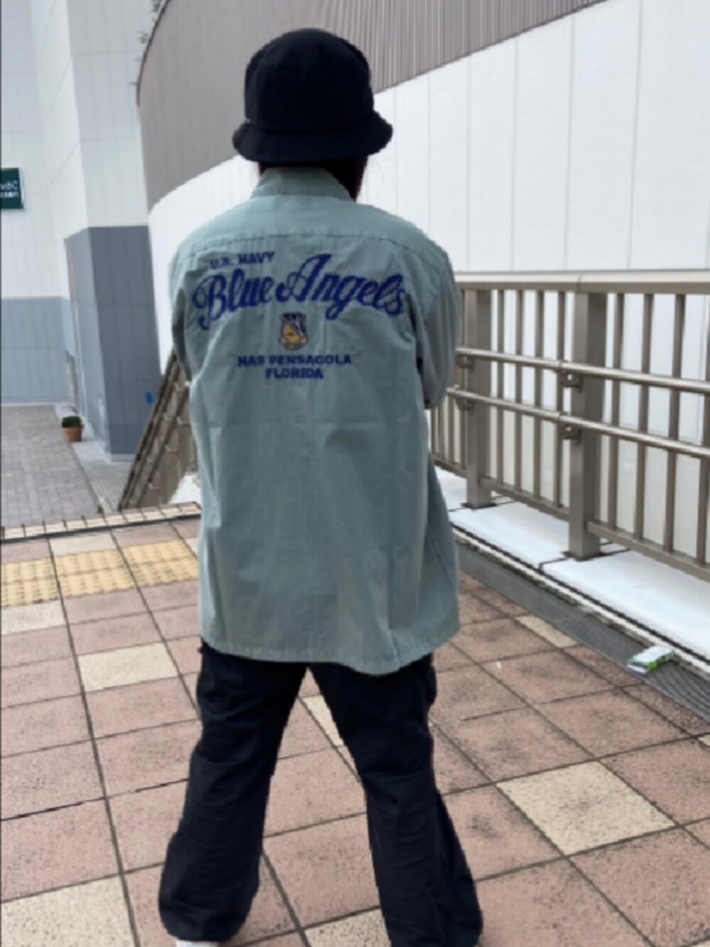 グリーン系のシャツ/ブラウス、ホワイト系のTシャツ/カットソー、ブラック系のハットを着用したレディースの夏コーディネートの2枚目の写真