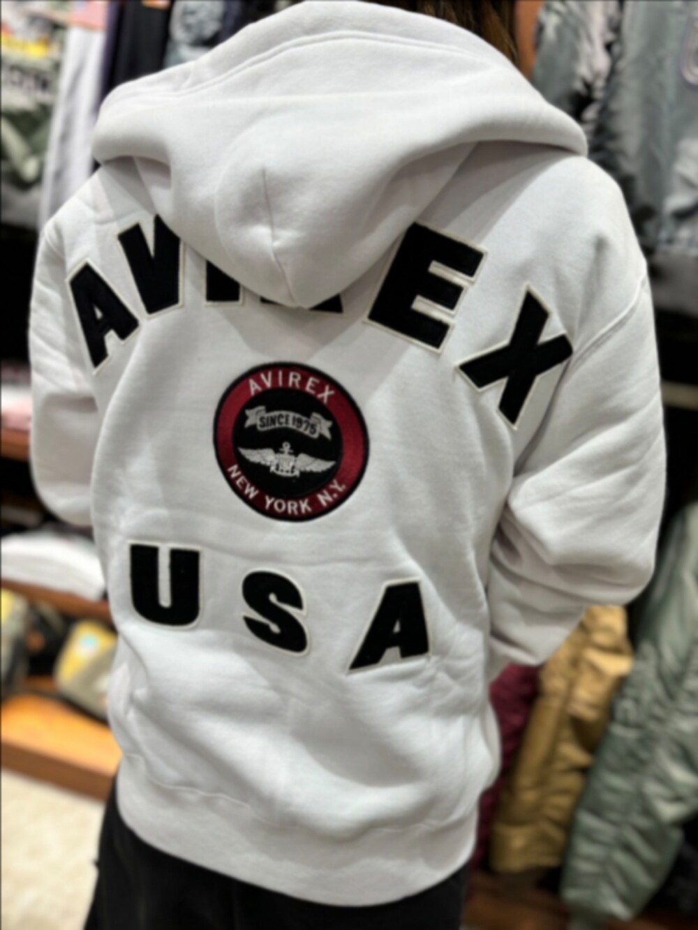 ホワイト系のパーカー、ブラック系のTシャツ/カットソー、ブラック系のニットキャップ/ビーニーを着用したレディースの秋コーディネートの3枚目の写真