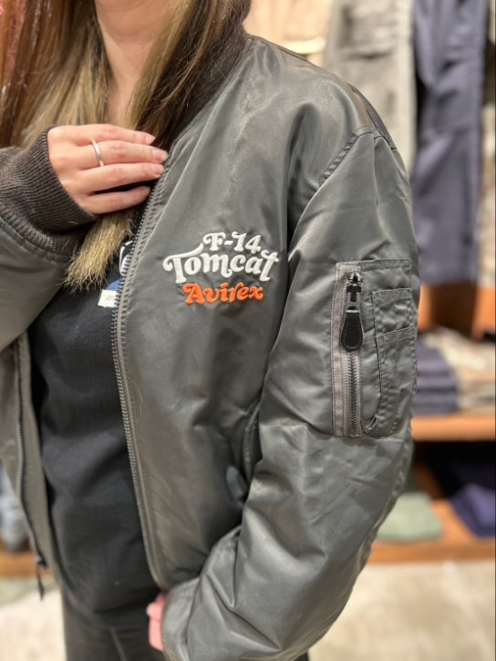 グレー系のMA-1、ブラック系のTシャツ/カットソー、ブルー系のキャップを着用したレディースの秋コーディネートの3枚目の写真