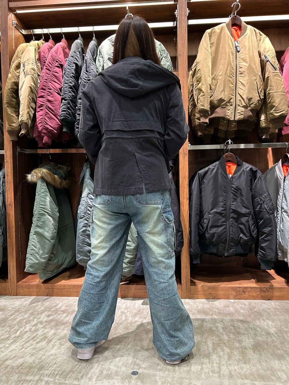 ブラック系のブルゾン、ホワイト系のTシャツ/カットソー、ブルー系のデニムパンツを着用したレディースの冬コーディネートの2枚目の写真