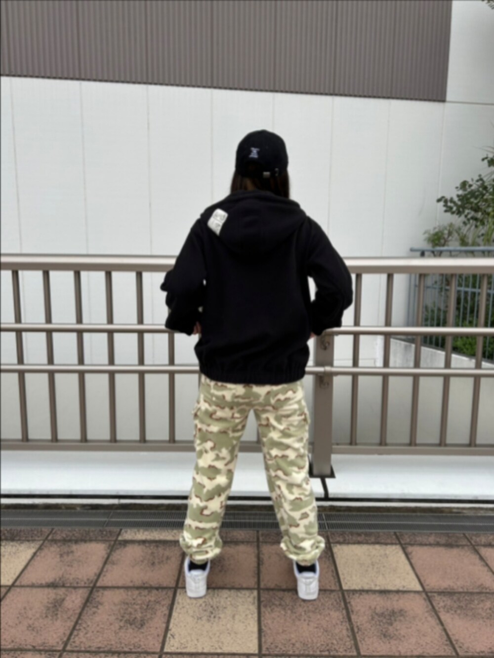 ベージュ系のパーカー、ベージュ系のカーゴパンツ、ブルー系のキャップを着用したレディースの秋コーディネートの2枚目の写真