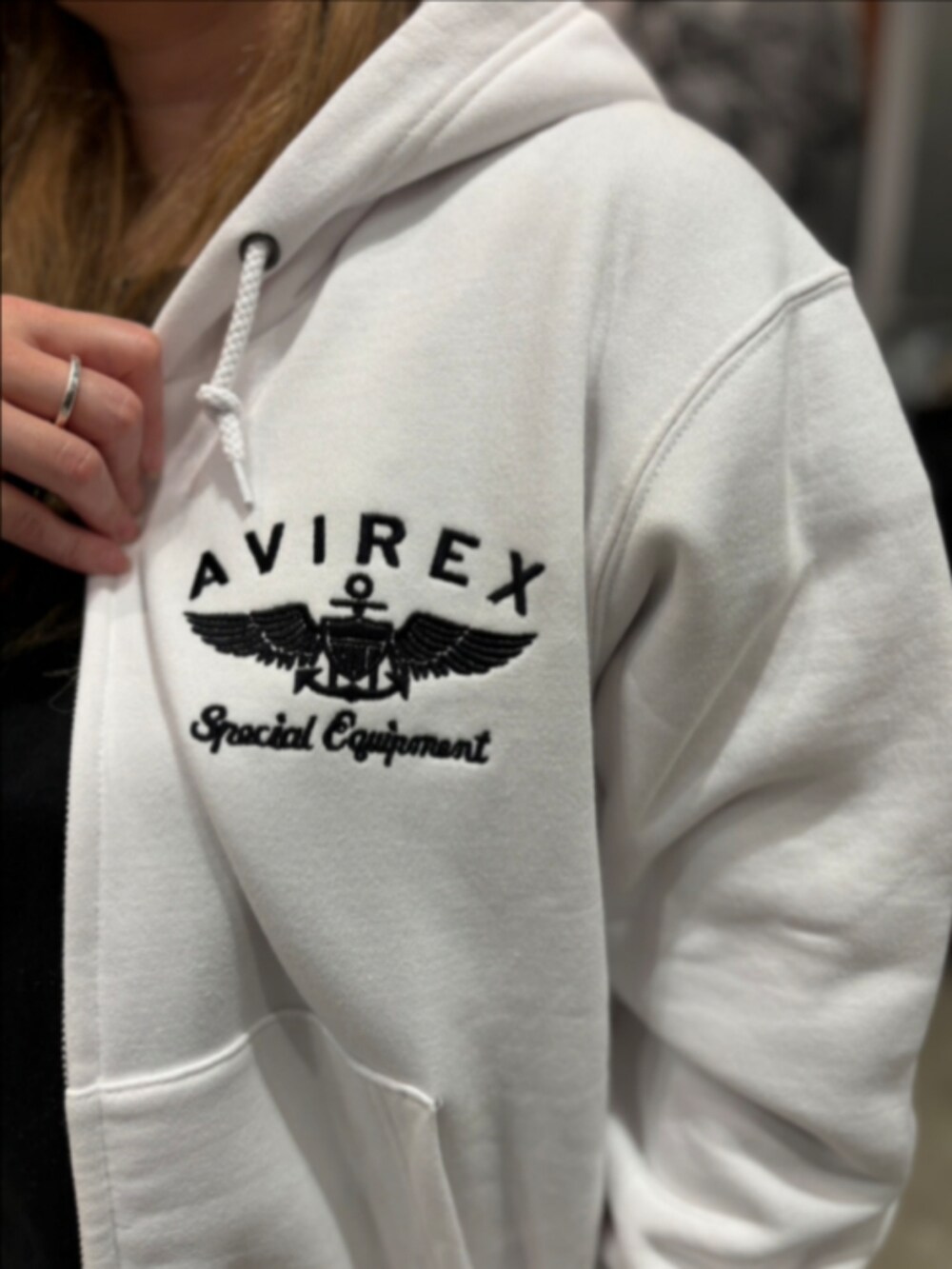 ホワイト系のパーカー、ブラック系のTシャツ/カットソー、ブラック系のニットキャップ/ビーニーを着用したレディースの秋コーディネートの4枚目の写真