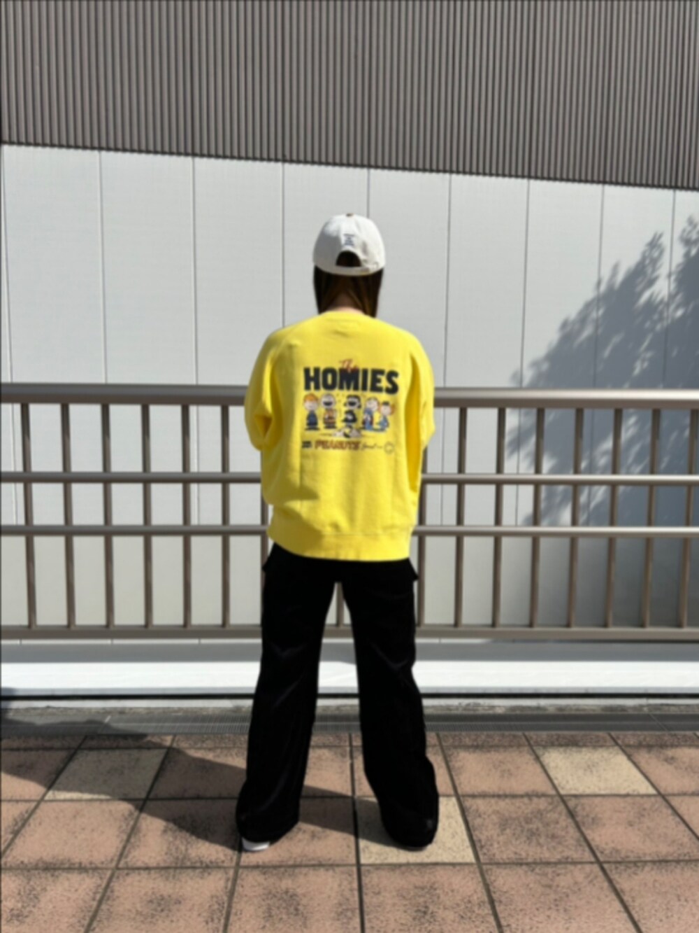 ブルー系のキャップを着用したレディースの秋コーディネートの2枚目の写真