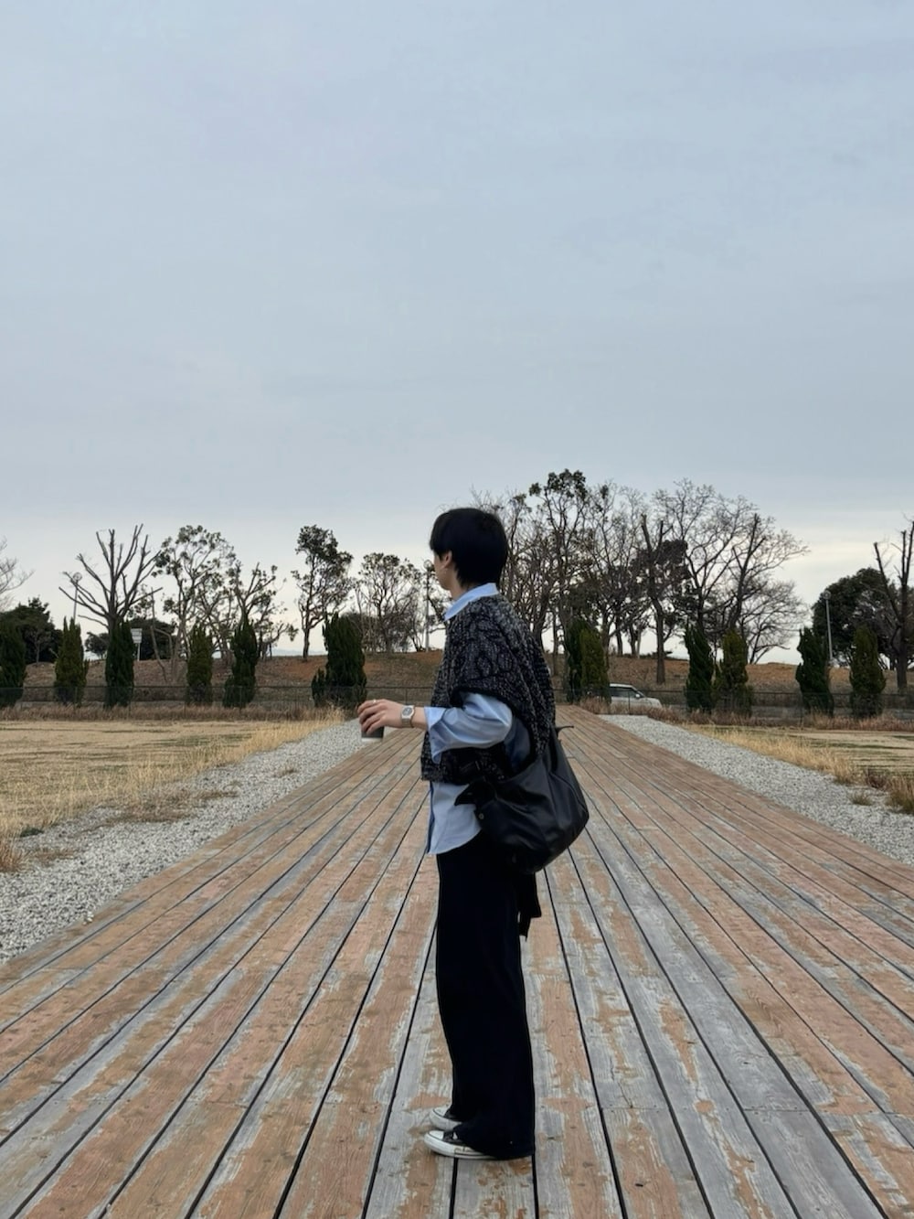 ブラック系のデニムパンツ、ブラック系のスニーカー、ブルー系のシャツ/ブラウスを着用したメンズの春コーディネートの3枚目の写真