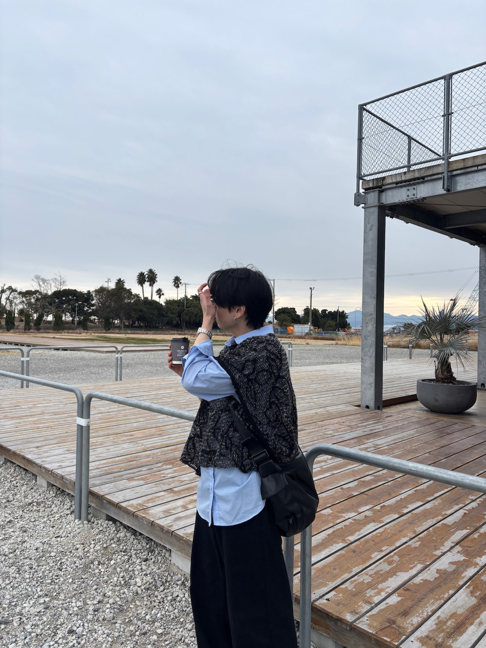 ブラック系のデニムパンツ、ブラック系のスニーカー、ブルー系のシャツ/ブラウスを着用したメンズの春コーディネートの2枚目の写真