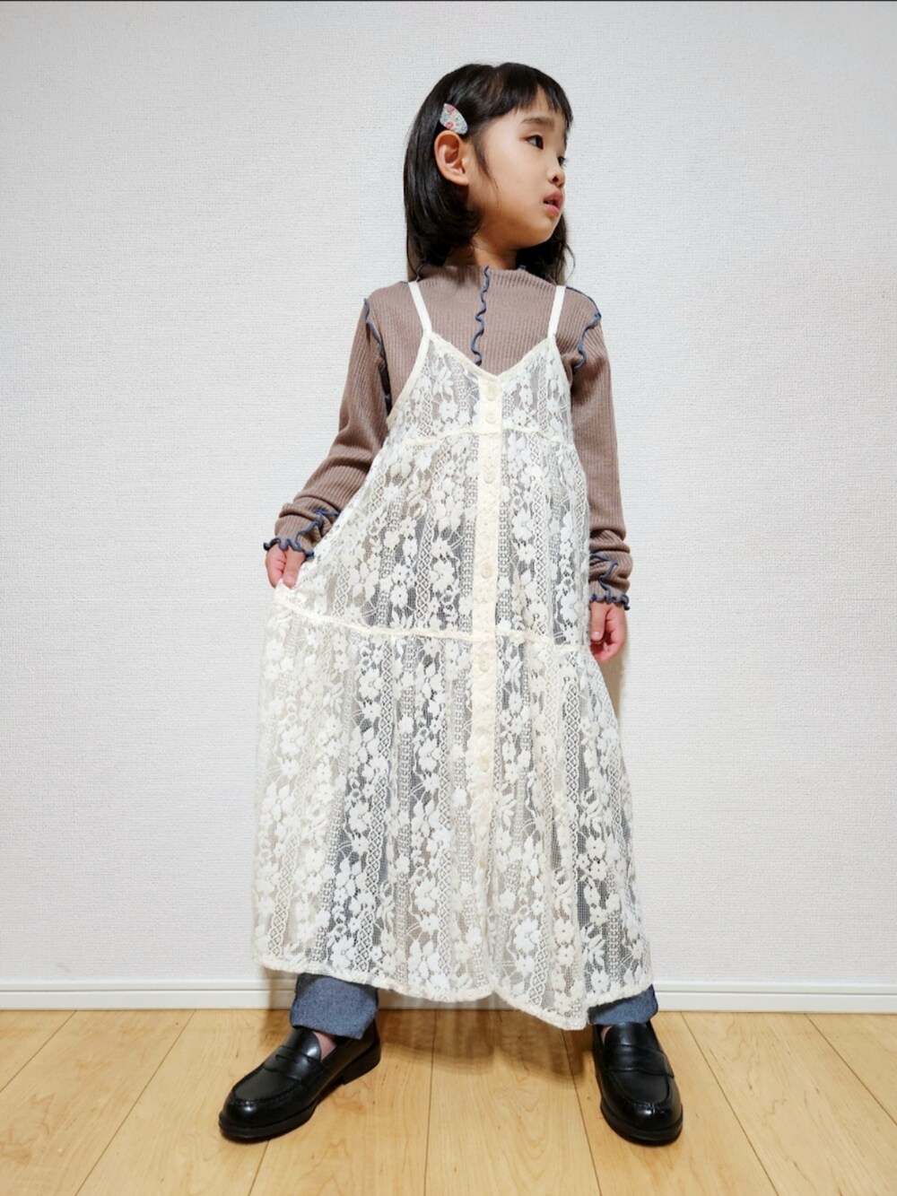ホワイト系のワンピース、ブラック系のブルゾン、ブルー系のデニムパンツを着用したキッズの冬コーディネートの5枚目の写真