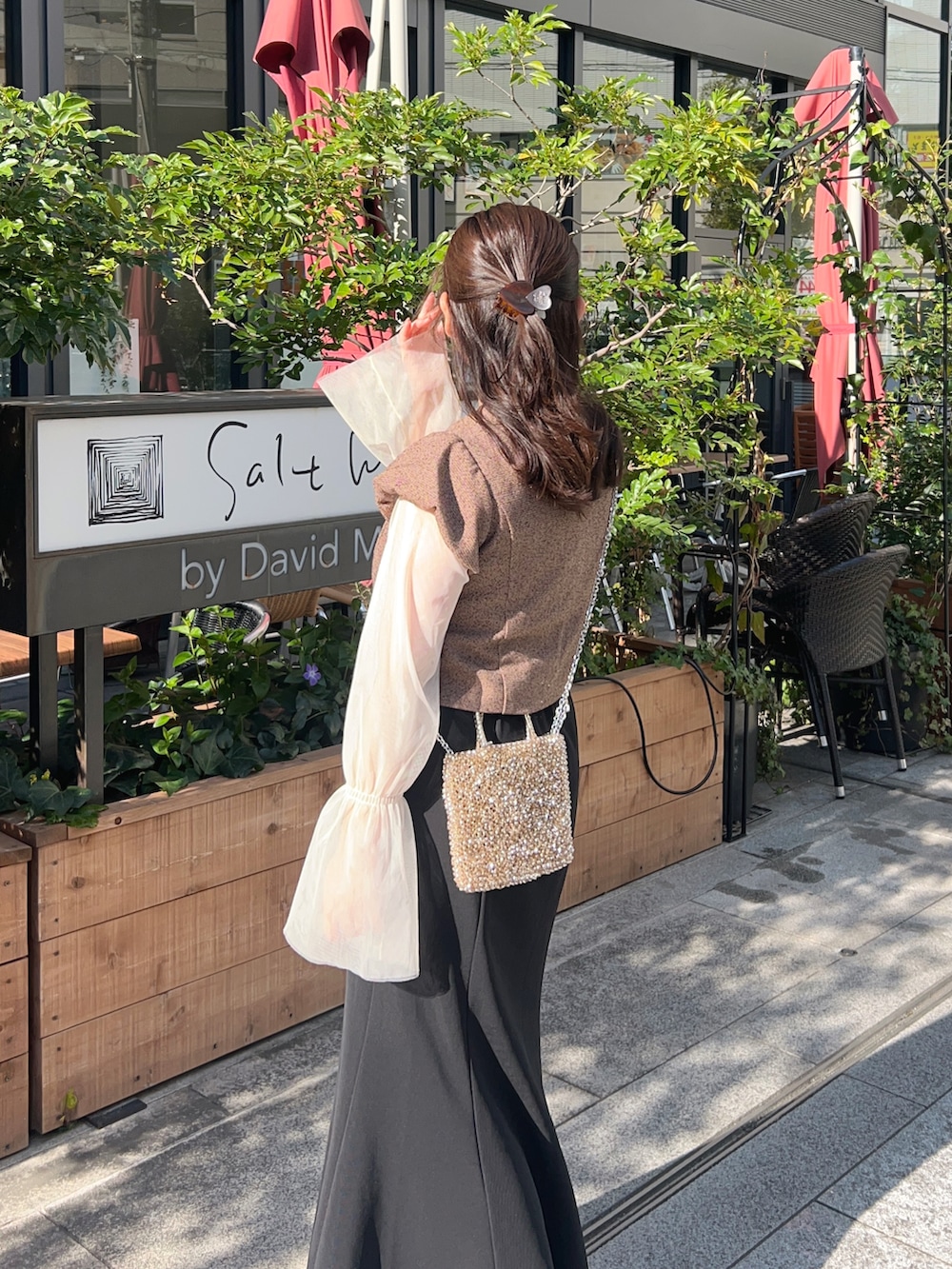 ブラック系のスカート、ブラウン系のノーカラージャケット、ホワイト系のTシャツ/カットソーを着用したレディースの春コーディネートの4枚目の写真