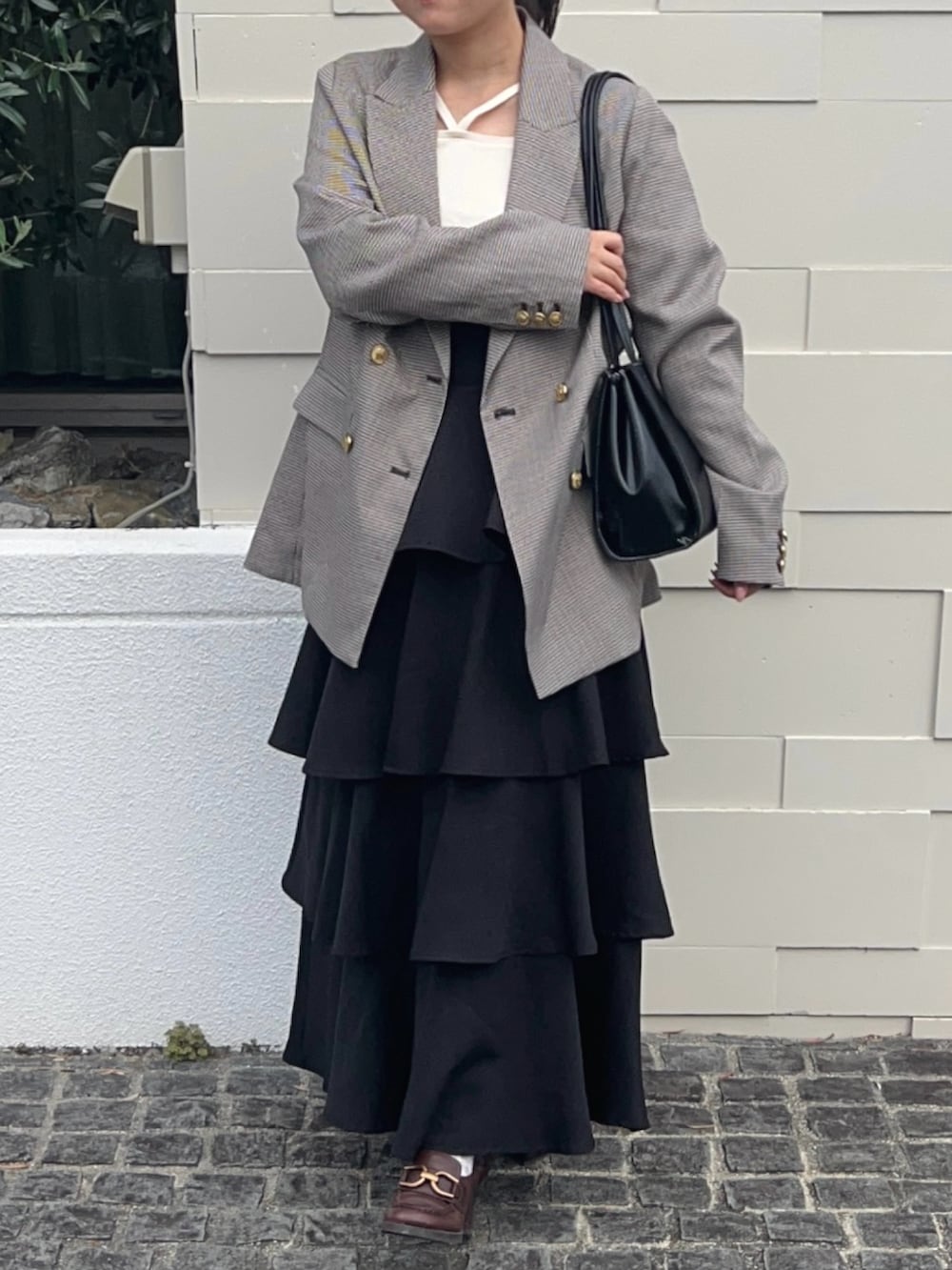 ブラウン系のテーラードジャケット、ブラウン系のパンプス、ホワイト系のニット/セーターを着用したレディースの秋コーディネートの5枚目の写真