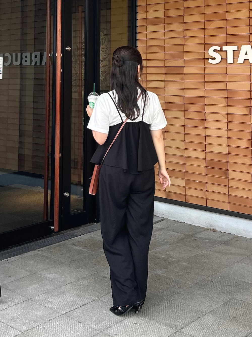 ブラック系のセットアップ、ブラック系のパンプス、ホワイト系のTシャツ/カットソーを着用したレディースの夏コーディネートの3枚目の写真