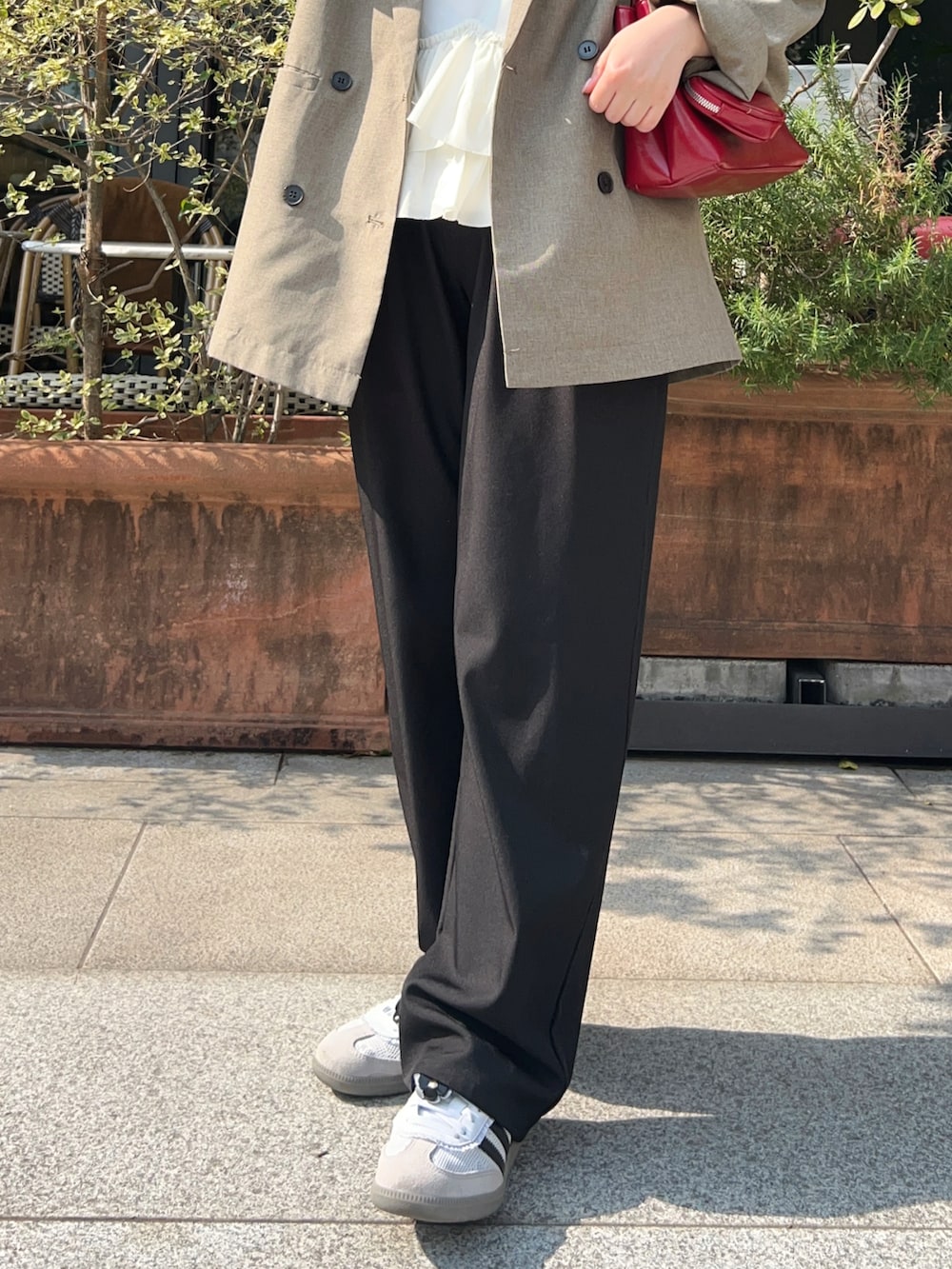 ベージュ系のテーラードジャケット、ブラック系のその他パンツ、ホワイト系のスニーカーを着用したレディースの春コーディネートの3枚目の写真