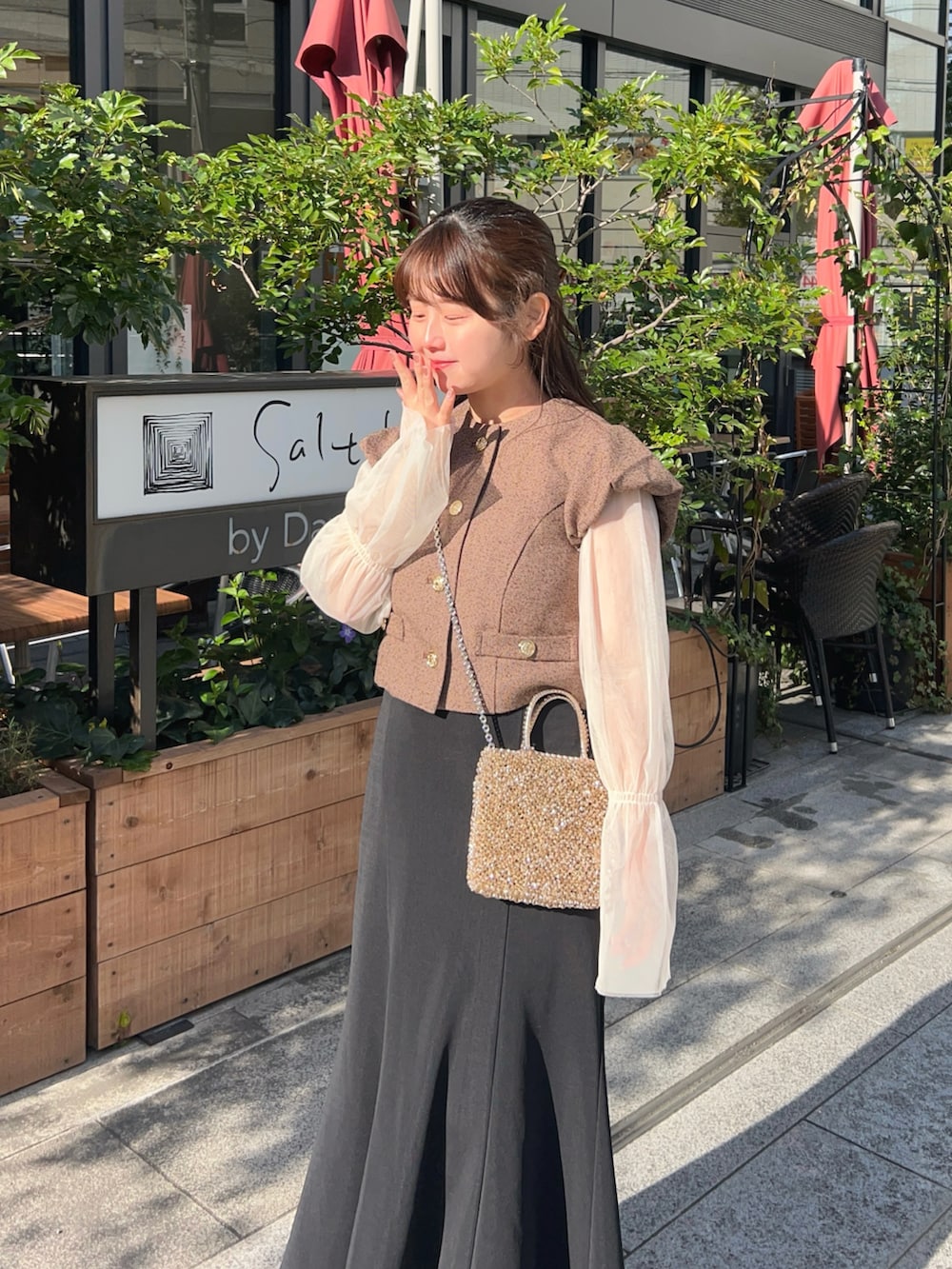 ブラック系のスカート、ブラウン系のノーカラージャケット、ホワイト系のTシャツ/カットソーを着用したレディースの春コーディネートの3枚目の写真