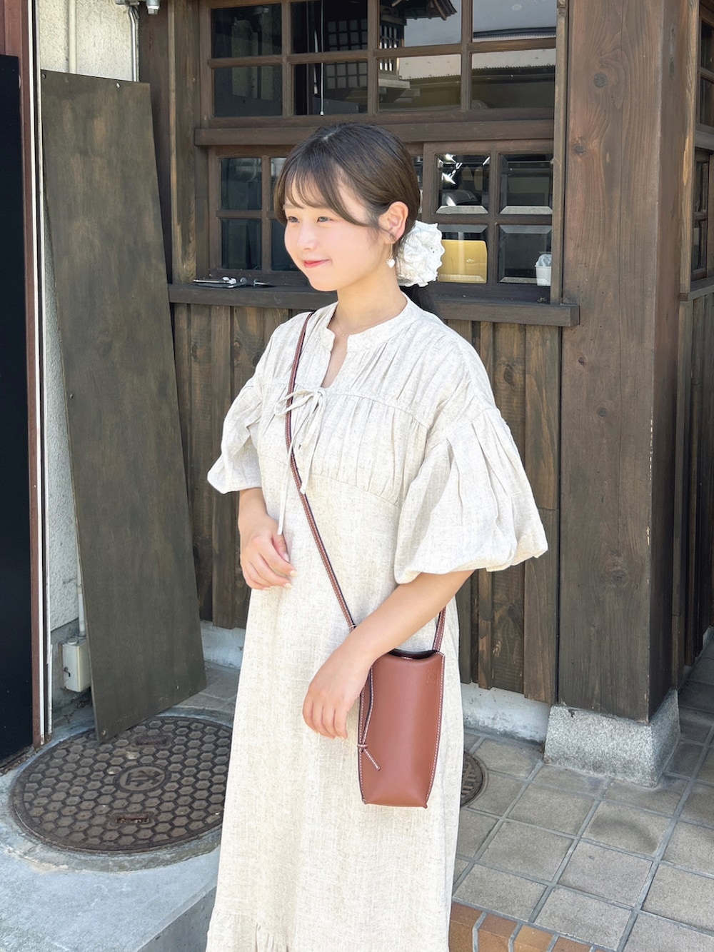 ホワイト系のキャミソール、ベージュ系のワンピース、ホワイト系のサンダルを着用したレディースの夏コーディネートの2枚目の写真