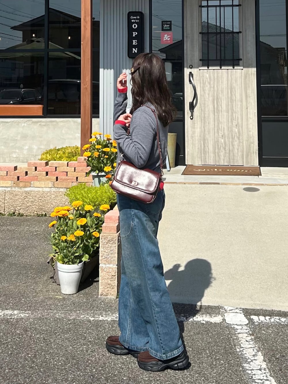 グレー系のカーディガン/ボレロ、ブラウン系のローファー、レッド系のショルダーバッグを着用したレディースの春コーディネートの2枚目の写真