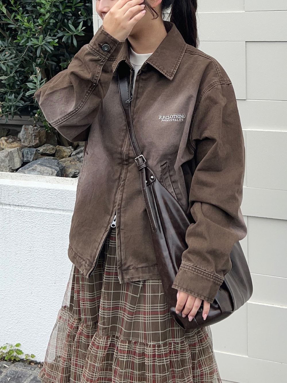 ブラウン系のスカート、ブラウン系のショルダーバッグ、ベージュ系のTシャツ/カットソーを着用したレディースの秋コーディネートの2枚目の写真