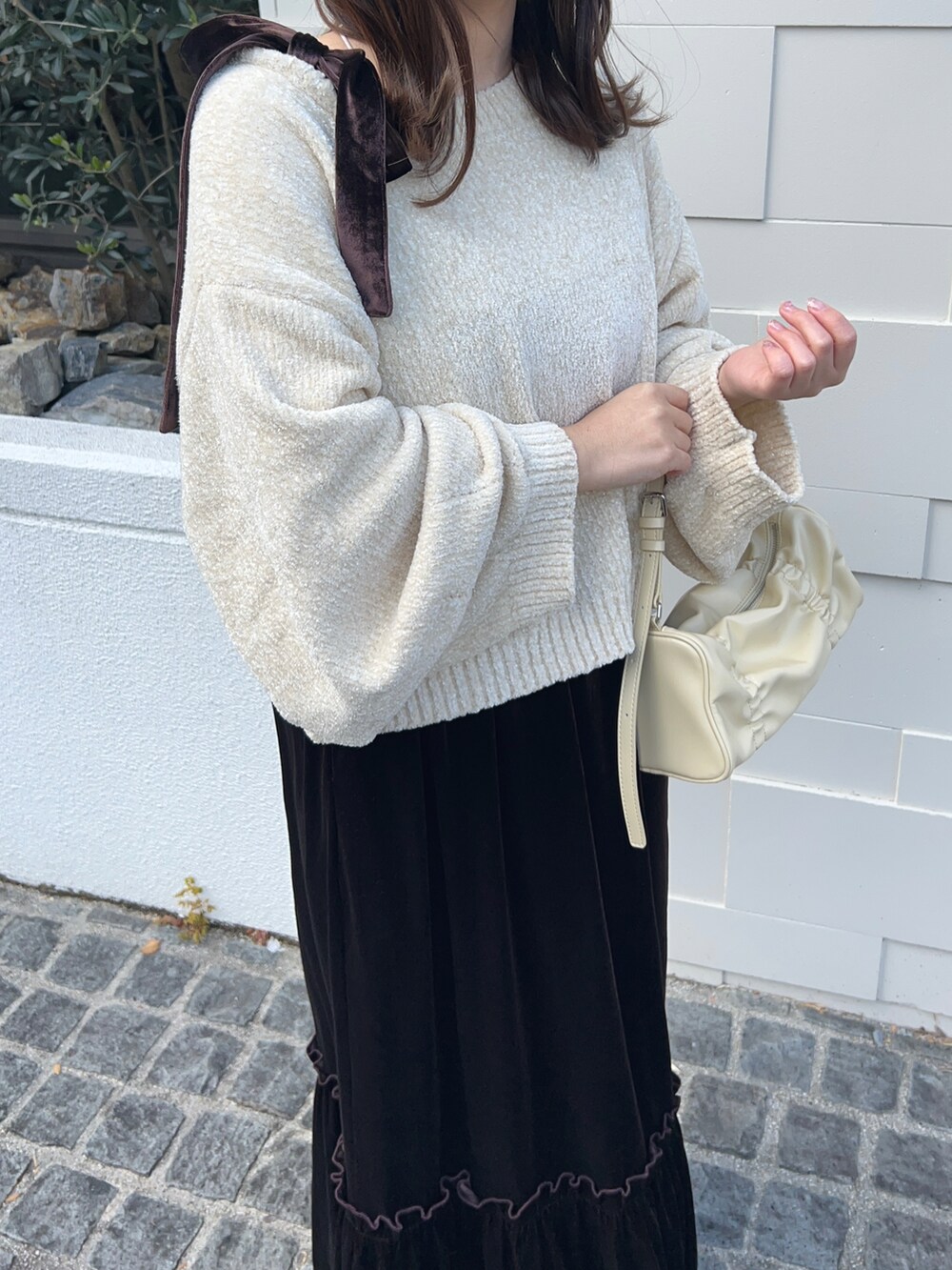 ホワイト系のニット/セーター、ブラウン系のワンピース、ブラウン系のシューズを着用したレディースの冬コーディネートの3枚目の写真