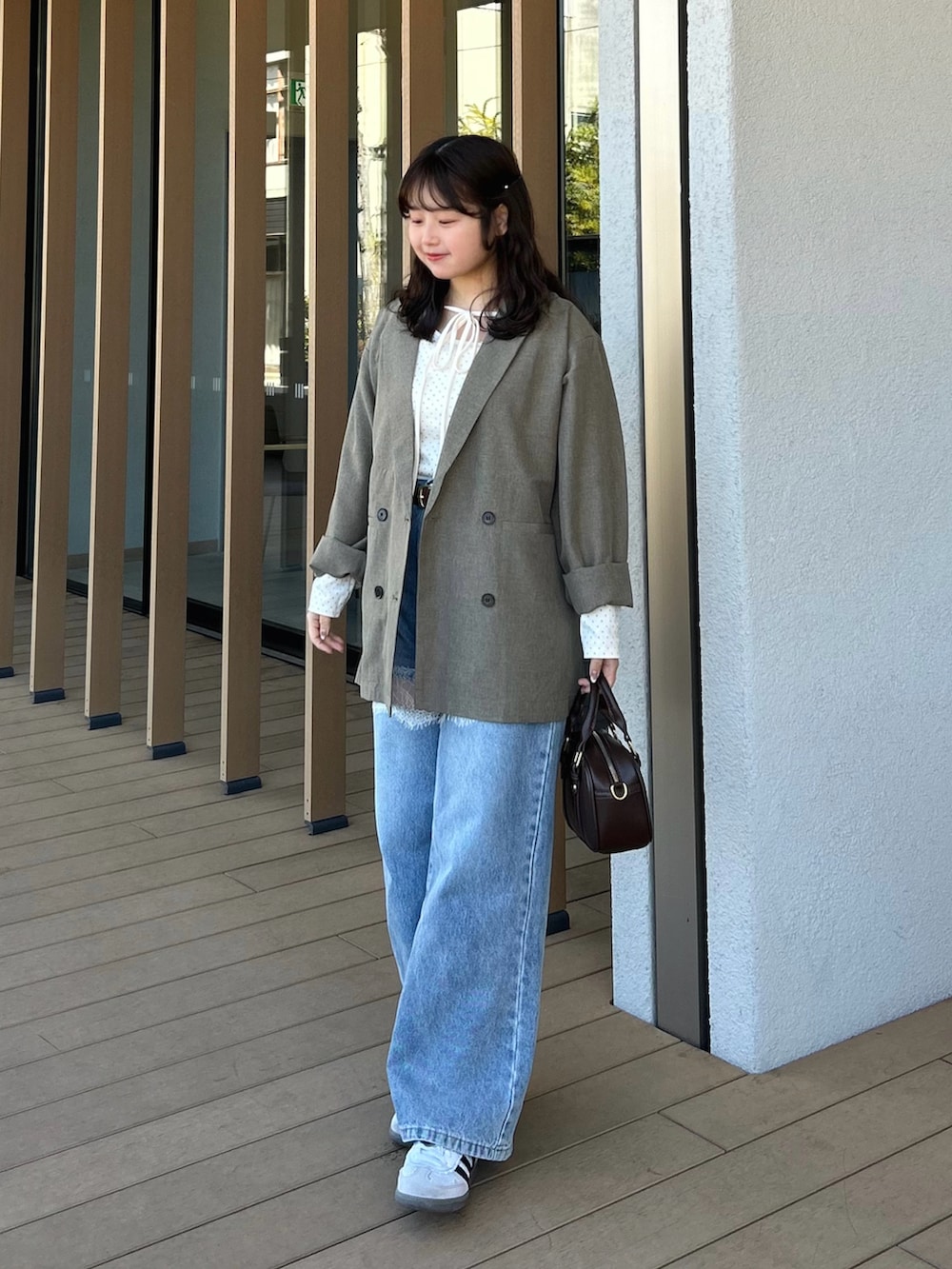 ホワイト系のTシャツ/カットソー、ベージュ系のテーラードジャケット、ブルー系のデニムパンツを着用したレディースの春コーディネートの2枚目の写真