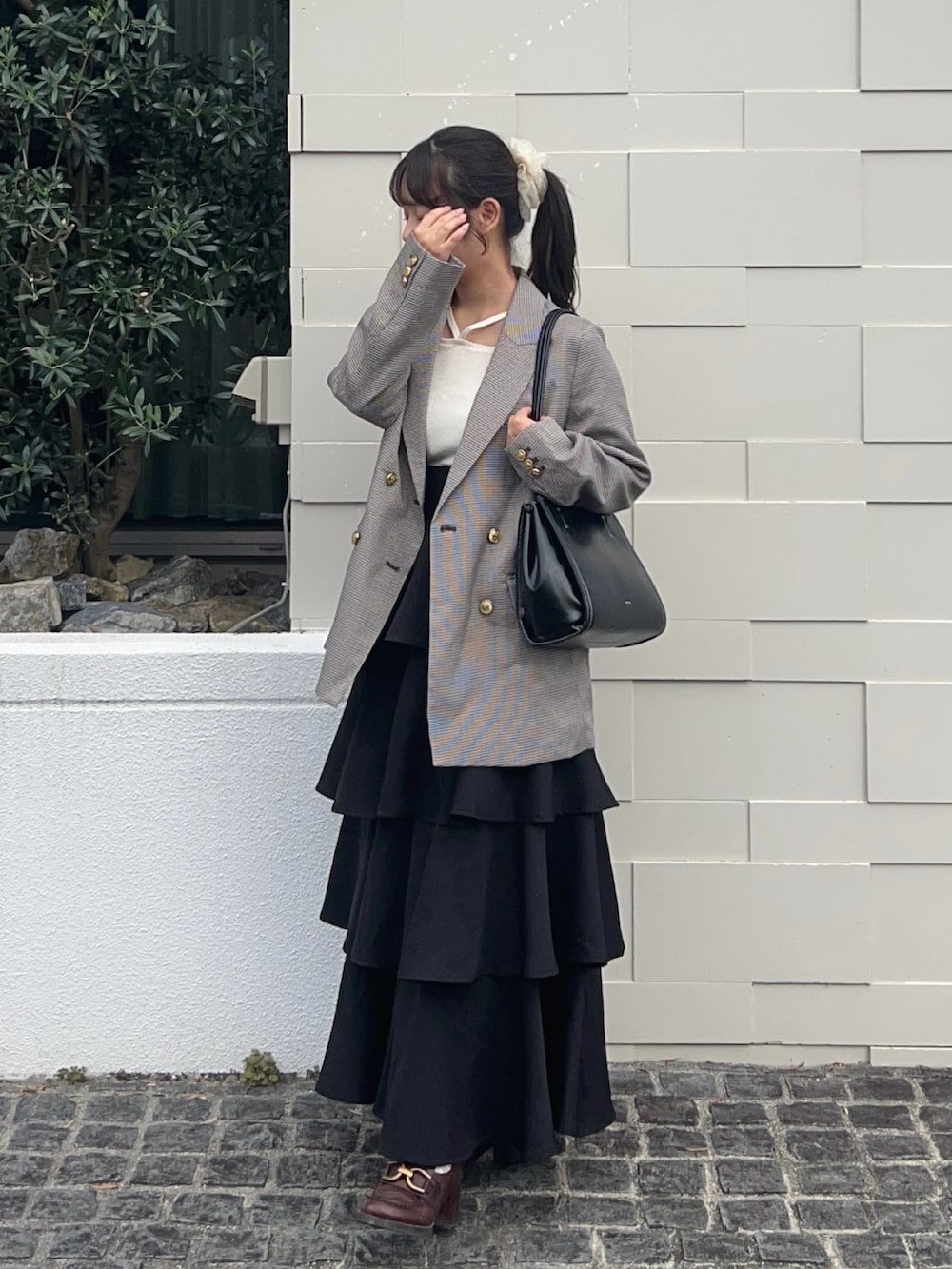 ブラウン系のテーラードジャケット、ブラウン系のパンプス、ホワイト系のニット/セーターを着用したレディースの秋コーディネートの3枚目の写真