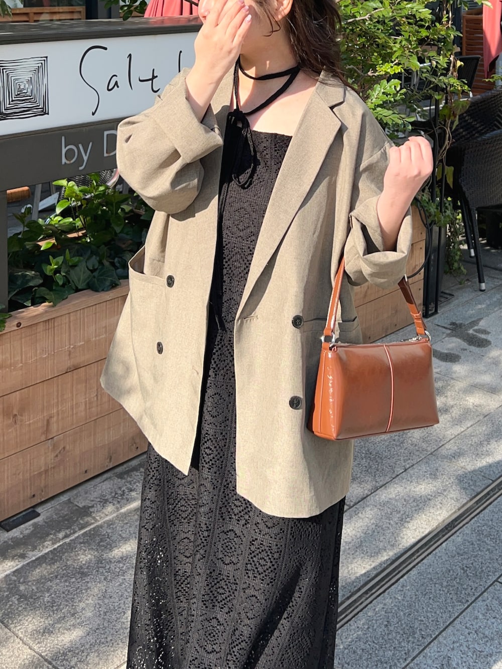 ベージュ系のテーラードジャケット、ブラック系のワンピース、その他のショルダーバッグを着用したレディースの春コーディネートの3枚目の写真