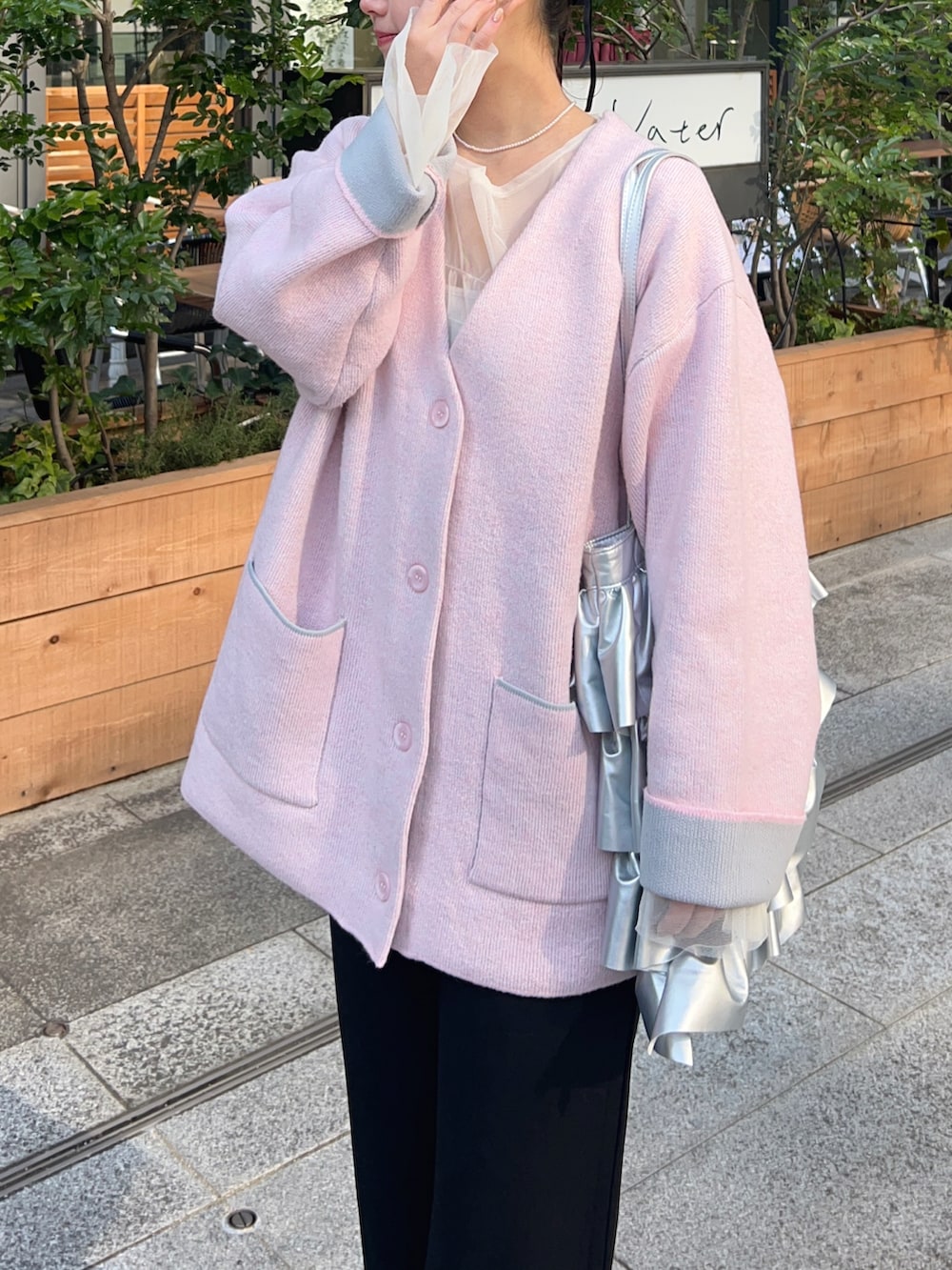 ピンク系のカーディガン/ボレロ、イエロー系のショルダーバッグ、ブラック系のその他パンツを着用したレディースの冬コーディネートの3枚目の写真
