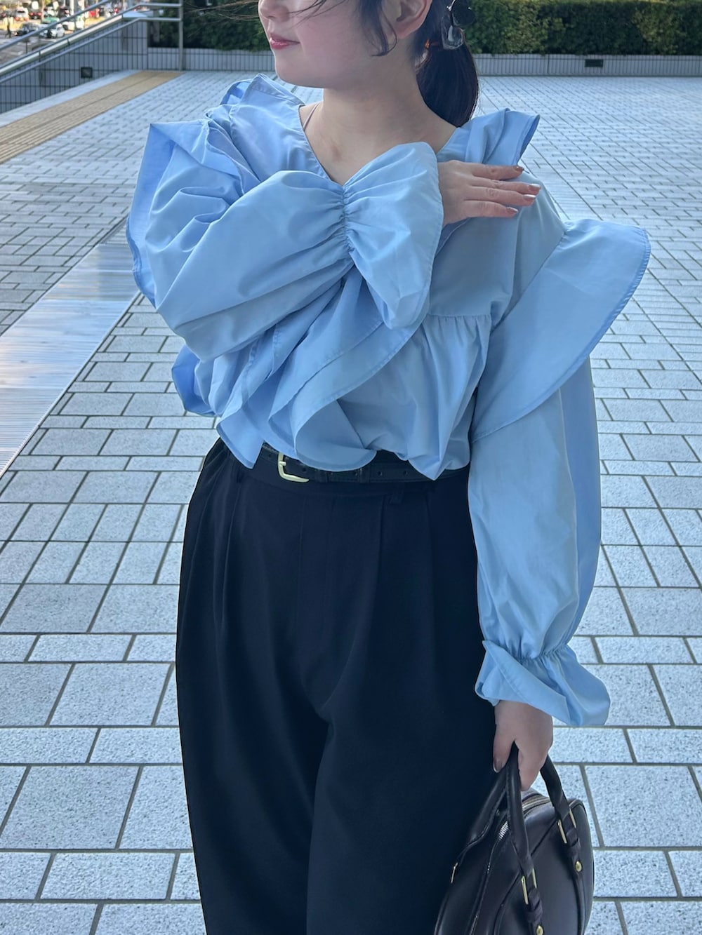 ブルー系のシャツ/ブラウス、ブラック系のその他パンツ、ブラウン系のボストンバッグを着用したレディースの春コーディネートの3枚目の写真