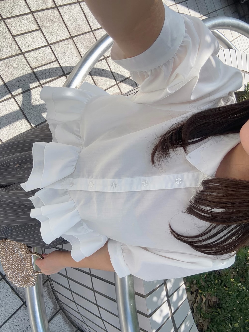 ホワイト系のシャツ/ブラウス、ホワイト系のパンプス、グレー系のスラックスを着用したレディースの夏コーディネートの5枚目の写真