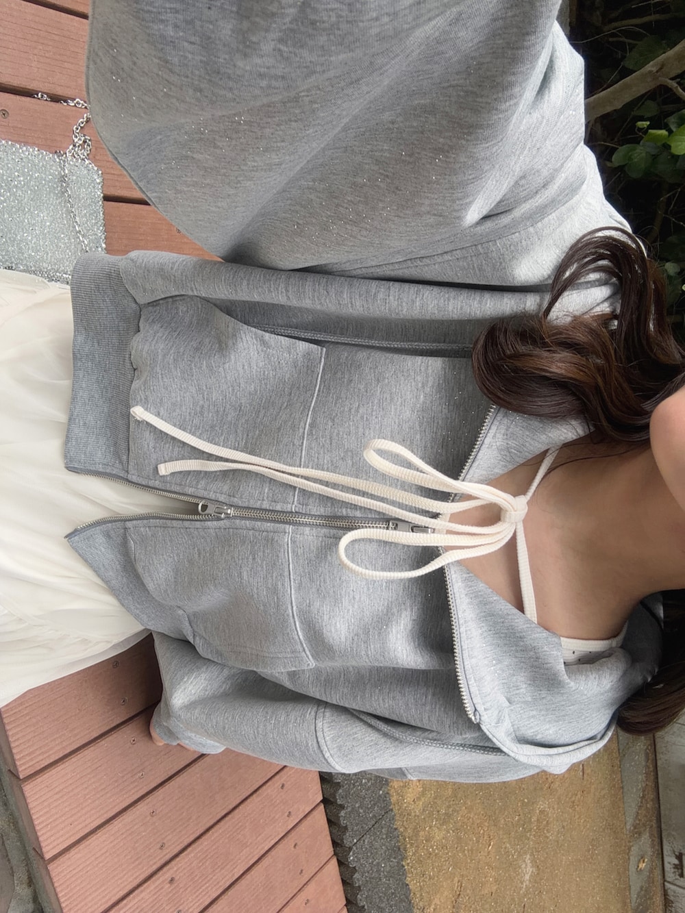 グレー系のパーカー、ホワイト系のスカート、ホワイト系のTシャツ/カットソーを着用したレディースの秋コーディネートの4枚目の写真