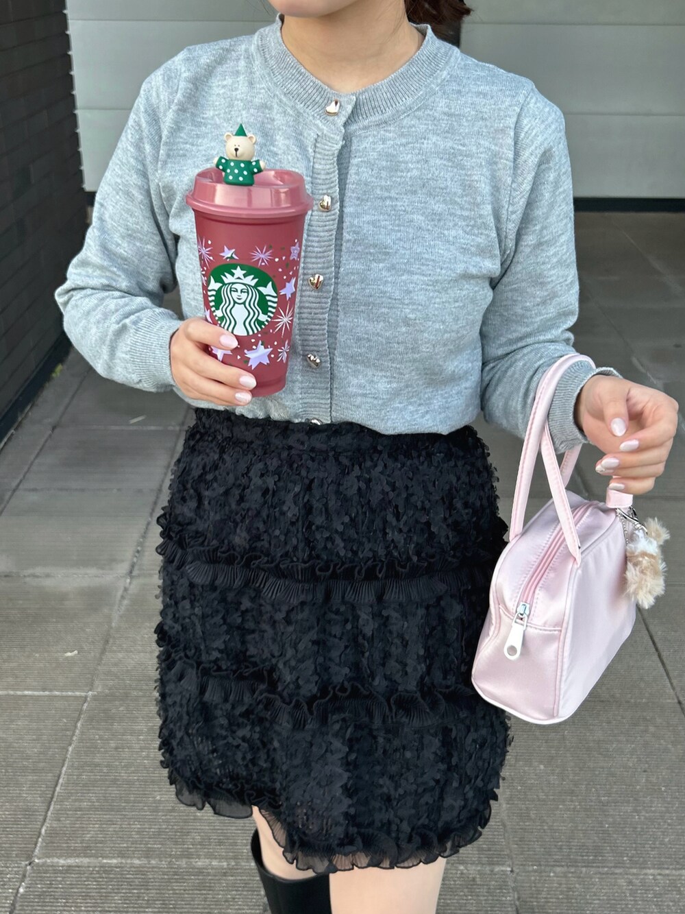 グレー系のカーディガン/ボレロ、ブラック系のスカート、ブラック系のブーツを着用したレディースの冬コーディネートの2枚目の写真
