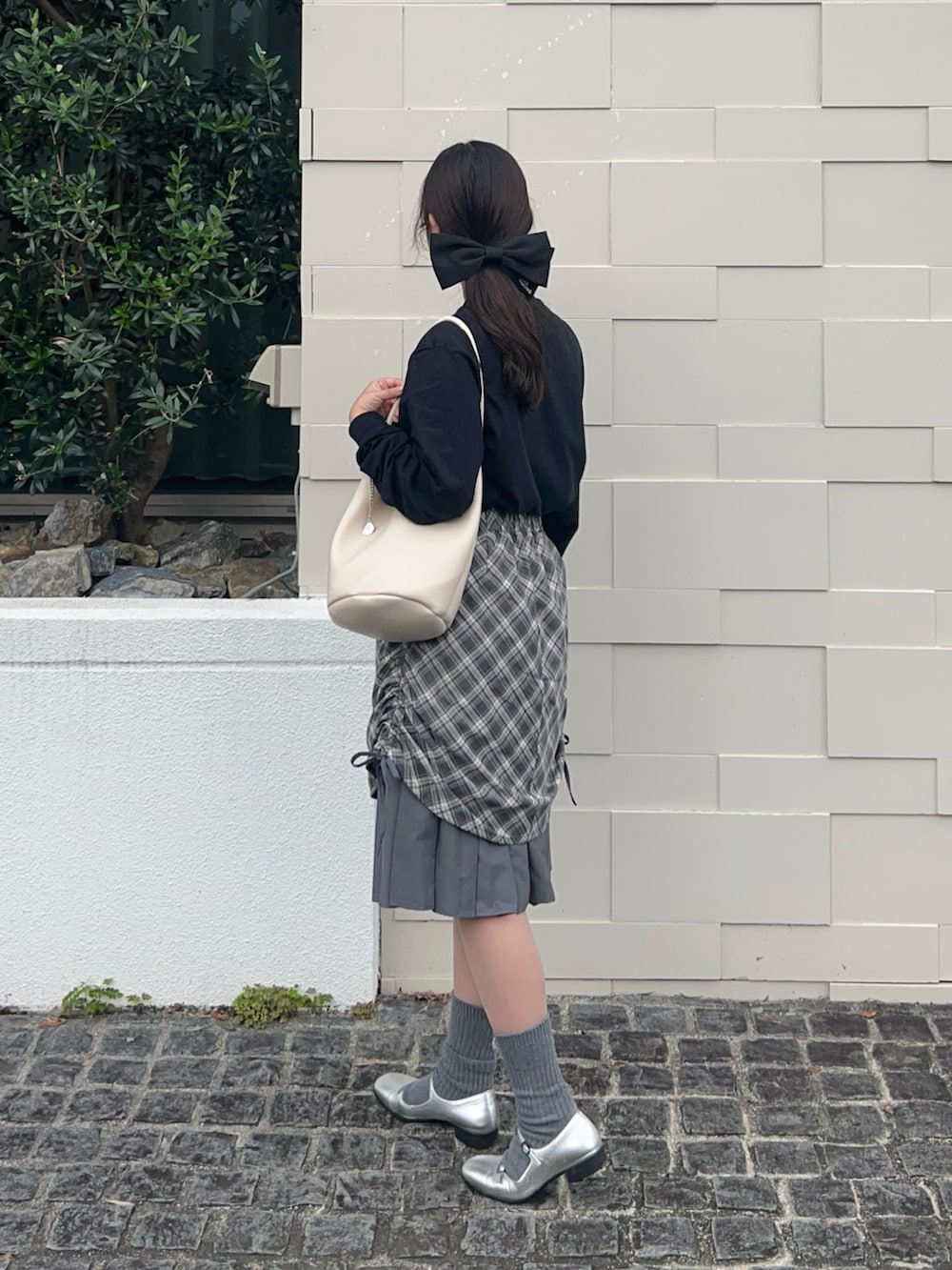 ブラック系のTシャツ/カットソー、シルバー系のパンプス、グレー系のスカートを着用したレディースの秋コーディネートの3枚目の写真