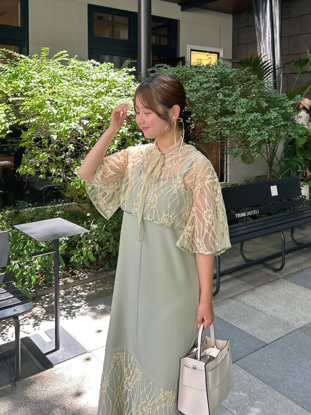 グリーン系のワンピース、ホワイト系のショルダーバッグ、ホワイト系のパンプスを着用したレディースの夏コーディネートの3枚目の写真