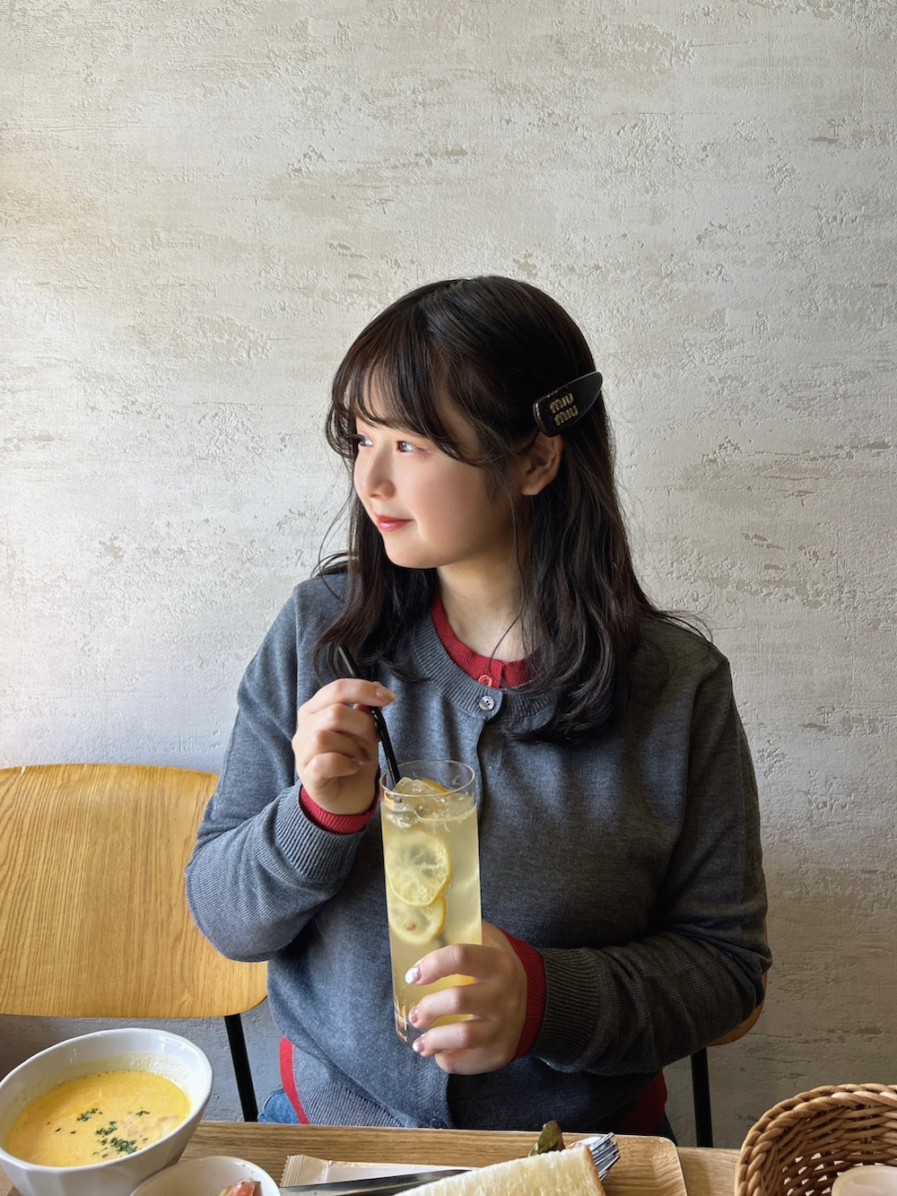 グレー系のカーディガン/ボレロ、ブラウン系のローファー、レッド系のショルダーバッグを着用したレディースの春コーディネートの3枚目の写真