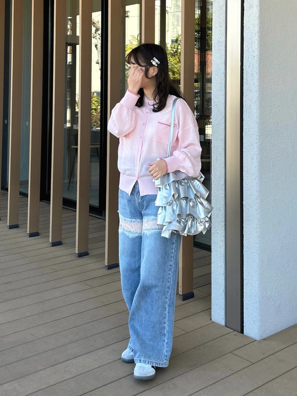 ブルー系のデニムパンツ、ピンク系のカーディガン/ボレロ、ホワイト系のタンクトップを着用したレディースの春コーディネートの2枚目の写真