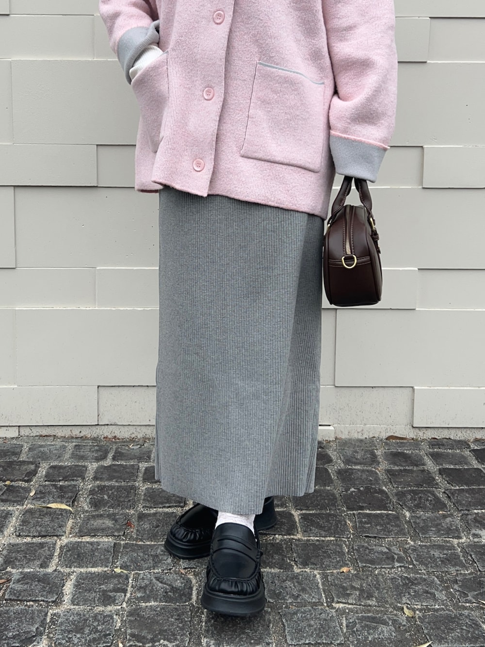 ピンク系のカーディガン/ボレロ、ホワイト系のTシャツ/カットソー、グレー系のスカートを着用したレディースの春コーディネートの3枚目の写真