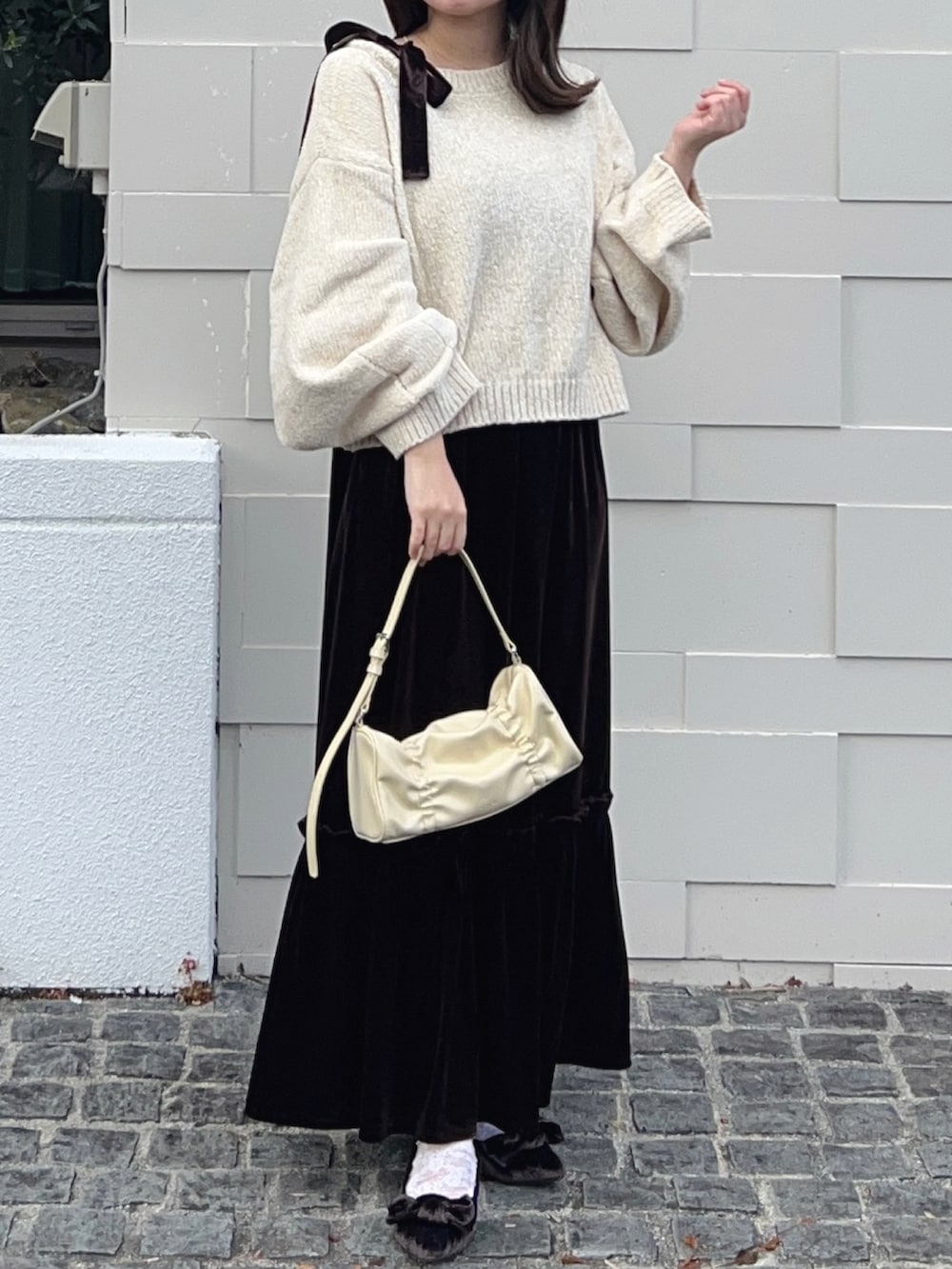 ホワイト系のニット/セーター、ブラウン系のワンピース、ブラウン系のシューズを着用したレディースの冬コーディネートの2枚目の写真