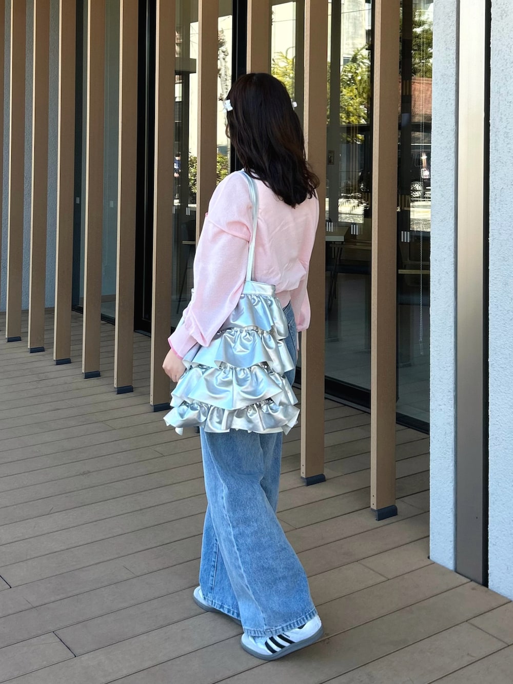 ブルー系のデニムパンツ、ピンク系のカーディガン/ボレロ、ホワイト系のタンクトップを着用したレディースの春コーディネートの3枚目の写真