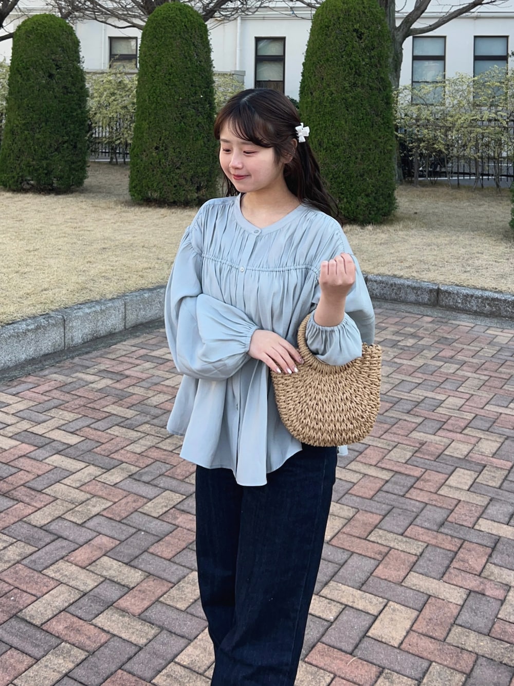 ホワイト系のローファー、ブルー系のシャツ/ブラウス、ベージュ系のかごバッグを着用したレディースの春コーディネートの3枚目の写真