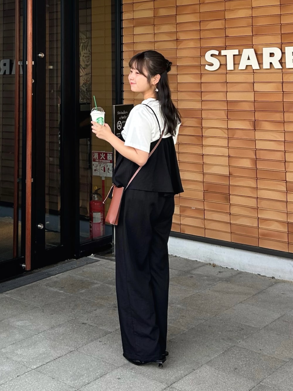 ブラック系のセットアップ、ブラック系のパンプス、ホワイト系のTシャツ/カットソーを着用したレディースの夏コーディネートの2枚目の写真
